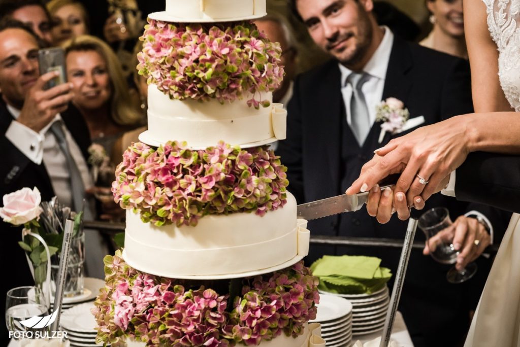 Hochzeit Salzburg Alte Residenz Braut hat beim Anschneiden der T